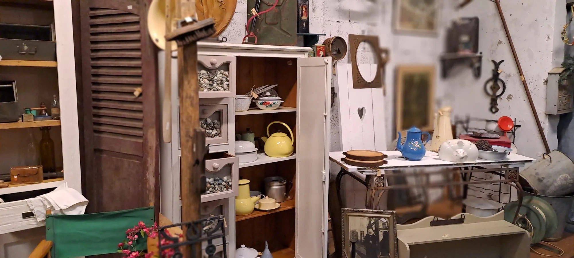 Brocantehoek met witte kast, emaille ketels en oude laden