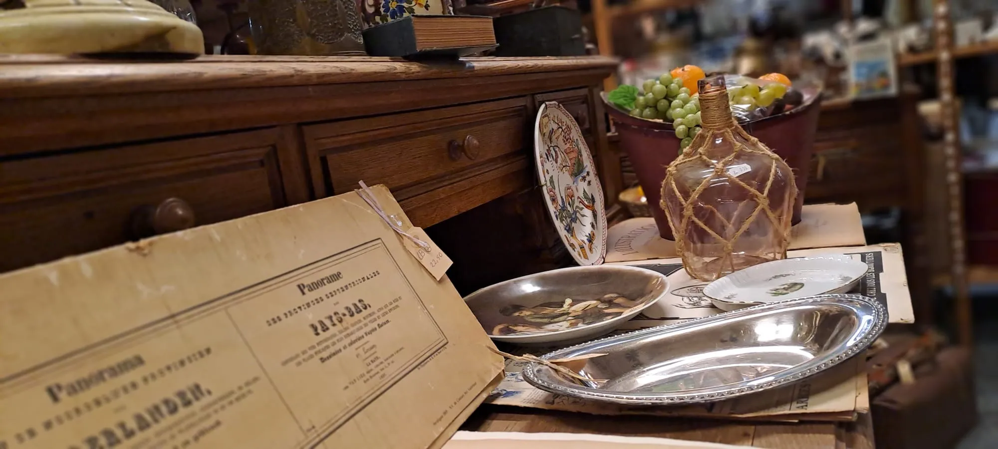 Brocante stilleven op een eiken dressoir met borden en een oude map