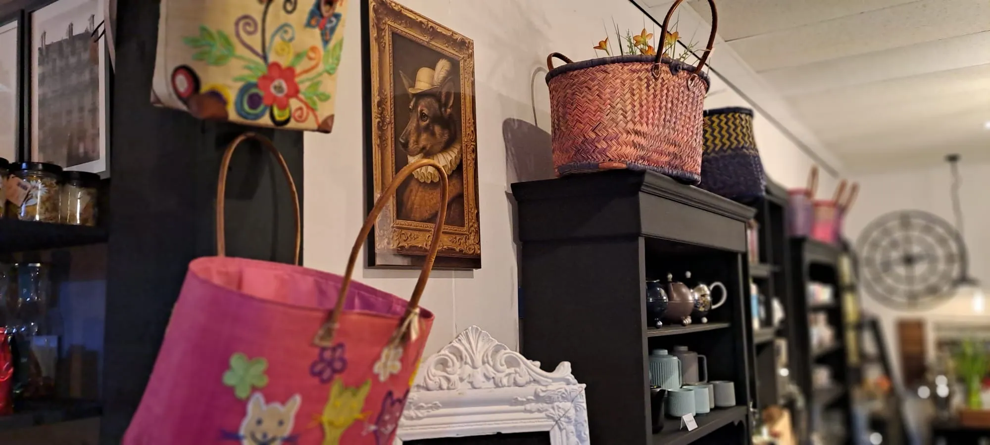 Wanddecoratie met manden, een schilderij en theepotten in de winkel